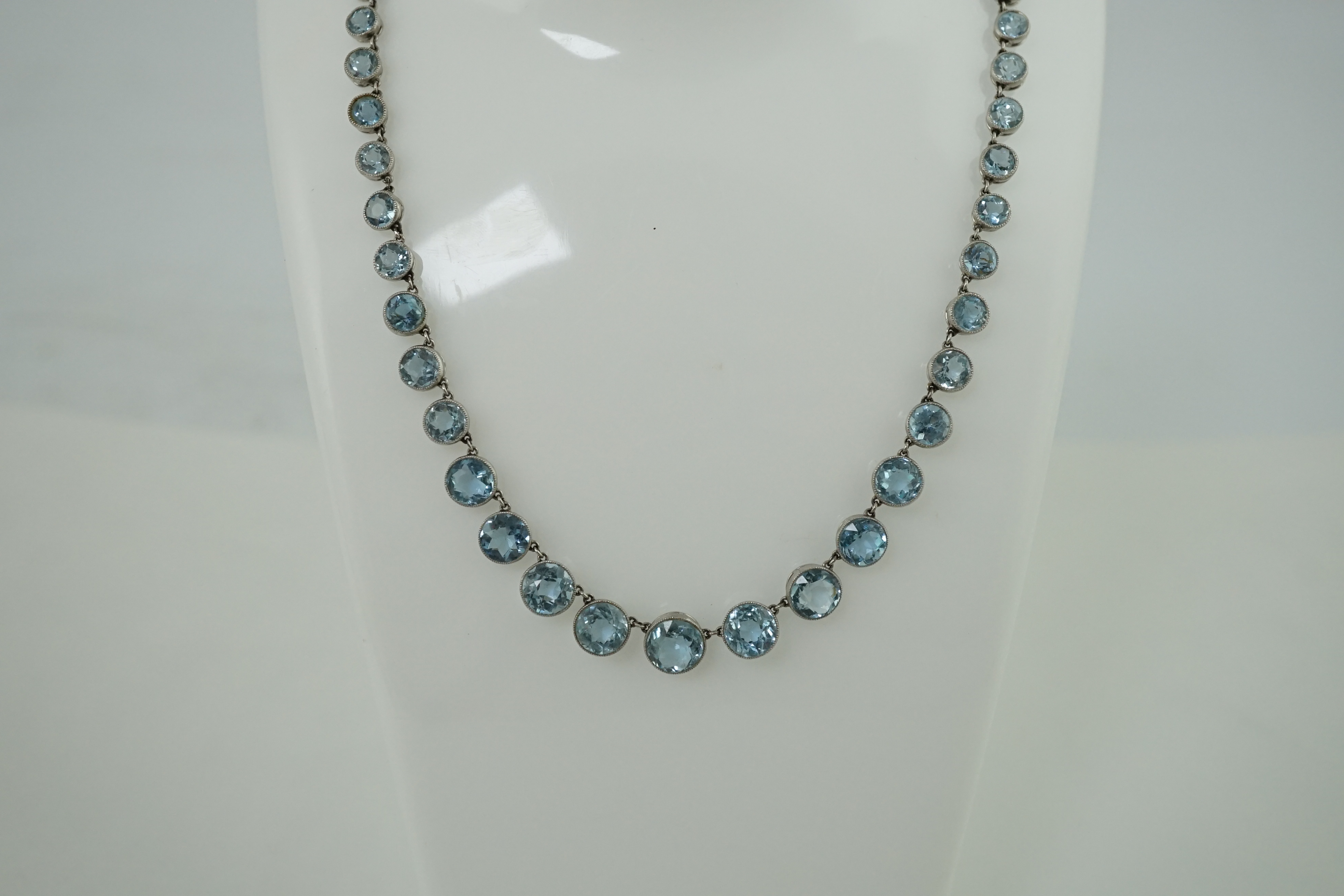 A Belle Epoque platinum and millegrain set graduated aquamarine necklace